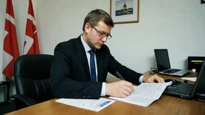 Dansk erhvervsadvokat gennemgår EU-sanktionsdokumenter mod Rusland på et konferencebord i København