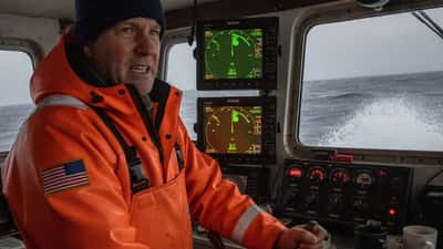 Capitán de barco pesquero en la cabina de mando durante una tormenta en el Mar de Bering