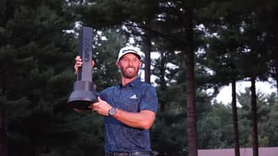 Dustin Johnson champion du LIV Golf Boston, tenant son trophée sur le green