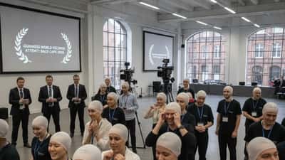 Group of people wearing professional bald caps at a Guinness World Records attempt event