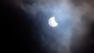 Partielle Sonnenfinsternis mit Wolken – die Sonne erscheint als heller Halbmond hinter Cirruswolken