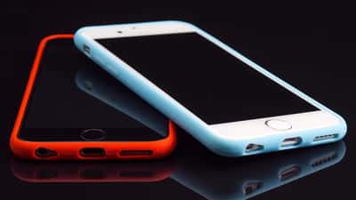 Due iPhone Apple su superficie bianca, pronti per la riparazione o il confronto
