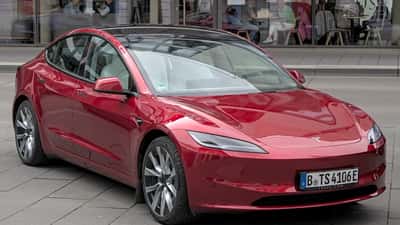 Tesla Model 3 eléctrico en exposición automovilística — crisis de concesionarios EV en EE.UU. 2026