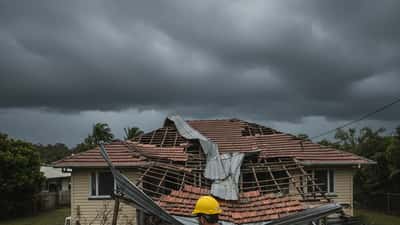 Building inspector examining storm-damaged roof after cyclone in Far North Queensland