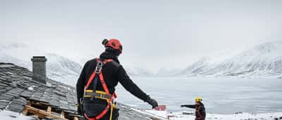 Norsk håndverker inspiserer stormskade på tak i Nordland
