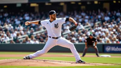 Lanzador zurdo de béisbol suelta la pelota desde el montículo durante un partido diurno