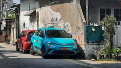 Grøn GreenSM VinFast elbil-taxa parkeret i bytrafik