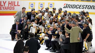 Pittsburgh Penguins players celebrating with the NHL Stanley Cup trophy
