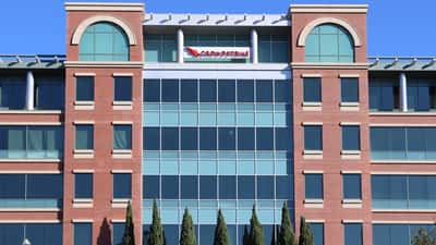 Edificio sede de CrowdStrike en Sunnyvale, California, con ticker CRWD en pantalla bursátil 2026