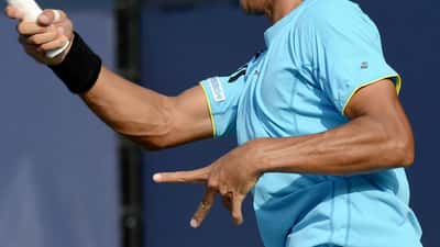 Male tennis player serving during a US Open qualifying round match