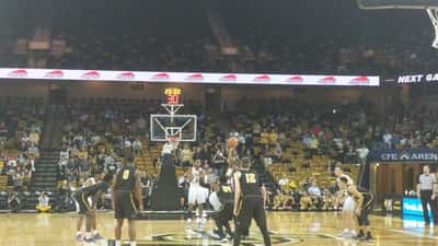 Basketball players competing during a college game tipoff, press photo documentary style