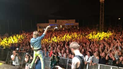 Publikum og musiker på scenen ved Smukfest i Skanderborg Dyrehave