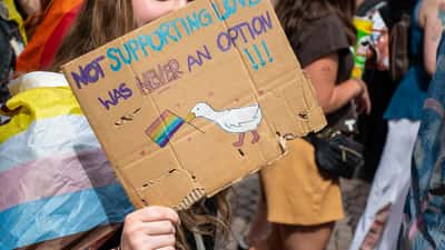 Teilnehmer des CSD Wiesbaden 2026 mit buntem Schild auf der Demonstration