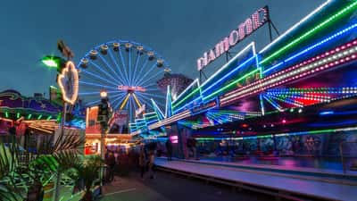 Kermis attracties en bezoekers op het festivalterrein in een Nederlandse binnenstad