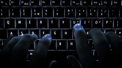 Clavier d'ordinateur rétroéclairé dans l'obscurité évoquant une cyberattaque ou une intrusion informatique