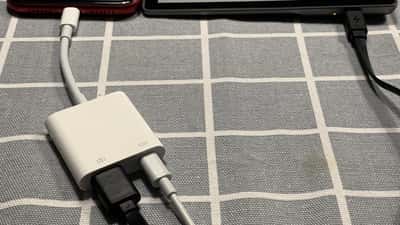 iPhone em cima de uma mesa com ecrã ligado, ao lado de um kindle, representando a decisão de atualização de dispositivos