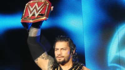 Roman Reigns WWE champion standing in the ring after retaining the World Heavyweight title