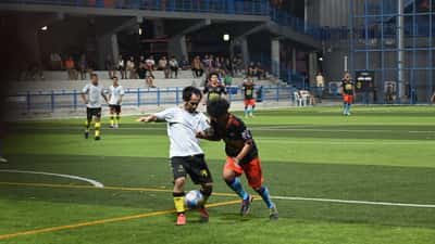 Two football players battling for possession during an evening soccer match