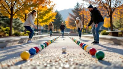 Players rolling bocce balls on an outdoor court toward the pallino