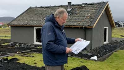 Íslenskur húseigandi skoðar stormskemmdar þakeiningar eftir páskahelgi 2026 með tryggingaskjal í hendi