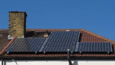 Monteur installiert Photovoltaikmodule auf einem Hausdach