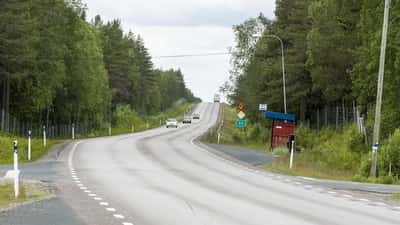 Bilar och lastbilar på E4 motorväg i norra Sverige med skog på båda sidor