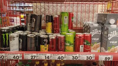 Colourful canned energy drink beverages including Red Bull and Monster
