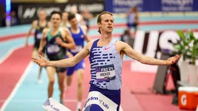 Elite 1500m runner in mid-stride on an indoor athletics track, representing competitive middle-distance running in Australia 2026