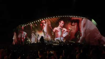 Concerto outdoor al Circo Massimo di Roma con folla e palco illuminato