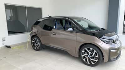 BMW i3 electric vehicle plugged into a home charging station
