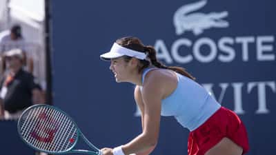 Emma Raducanu en la pista de tenis durante el Miami Open 2025, concentrada antes de golpear la pelota