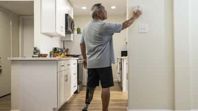 Persoon die rookmelder test als controle voor woningveiligheid
