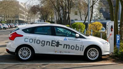 Elektroauto-Ladestation in Deutschland, modernes E-Auto an Ladesäule angeschlossen