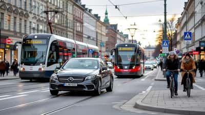 Autoilija ajaa Helsingin jaetulla ratikkakadulla, kojelautakamera tuulilasissa ja raitiovaunu taustalla
