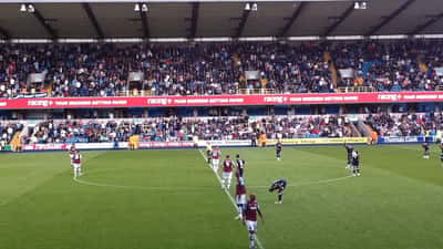 Millwall en West Ham supporters op het veld voor de derby te Londen