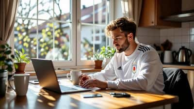 Dansk AGF-fan tjekker rejsebudget og betalingskort på laptop før udrejse til Poznań i Polen
