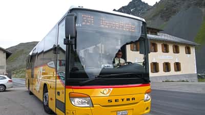 Bus traversant le col du Flüelapass en été, paysage alpin des Grisons en Suisse