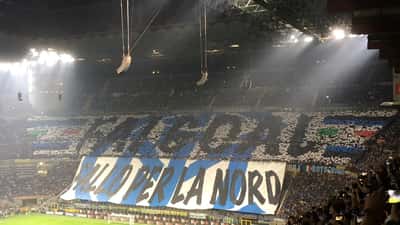 Estádio Giuseppe Meazza com torcida da Inter Milan e faixas de apoio durante partida da Serie A