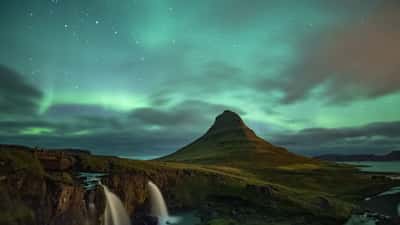 Aurores boréales spectaculaires au-dessus d'un paysage montagneux nocturne