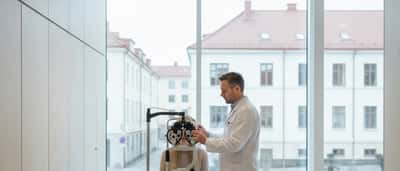 Norsk kvinne under synstest med foropter hos optiker i moderne klinikk i Oslo