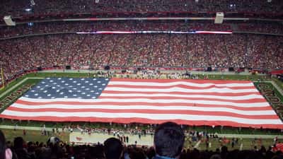 NFL players competing in an American football game at a packed stadium