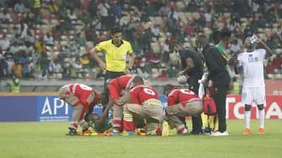 Paramedicinere hjælper en skadet fodboldspiller på banen