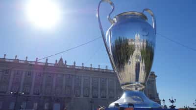Decoração da Plaza del Oriente em Madri relacionada à final da Champions League, com taças e bandeiras ao fundo