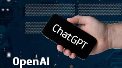 Main tenant un smartphone affichant l'interface ChatGPT et le logo OpenAI