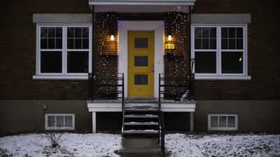 Quebec City street lined with snow-covered homes after a spring snowstorm, showing heavy accumulation on roofs