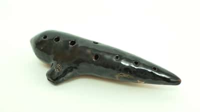 Keramische ocarina muziekinstrument, geblazen door een leerling in een muziekles