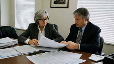 Canadian wealth advisor reviewing estate planning documents with a client in a Toronto office setting