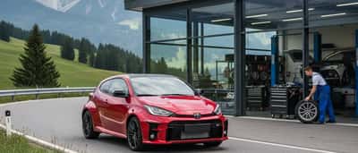 Toyota GR Yaris 2026 auf einer Bergstraße mit Werkstatt im Hintergrund
