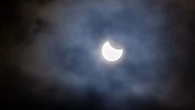 Éclipse solaire partielle avec nuages en Suisse, observation astronomique août 2026
