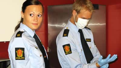 Norsk politibetjent som sikrer DNA-bevis på et åsted i uniform
